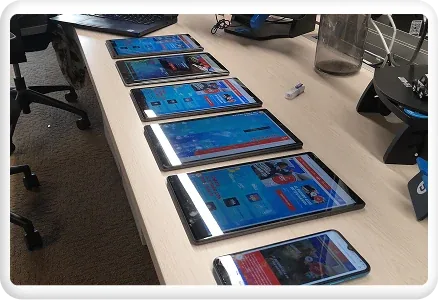 Los celulares y tablets preparados para el testeo, en fila sobre la mesa